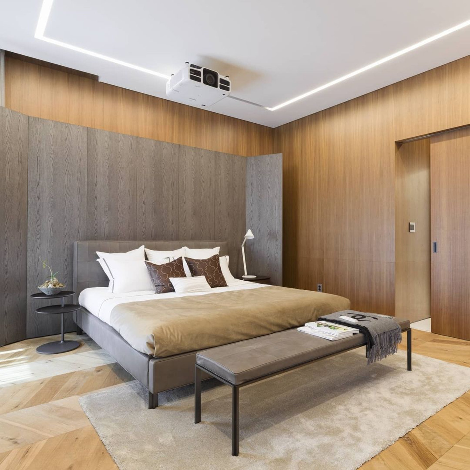 Phòng ngủ được thiết kế với phong cách tối giản, toát lên sự ấm áp nhờ tông màu gỗ và sắc xám trầm ấm.