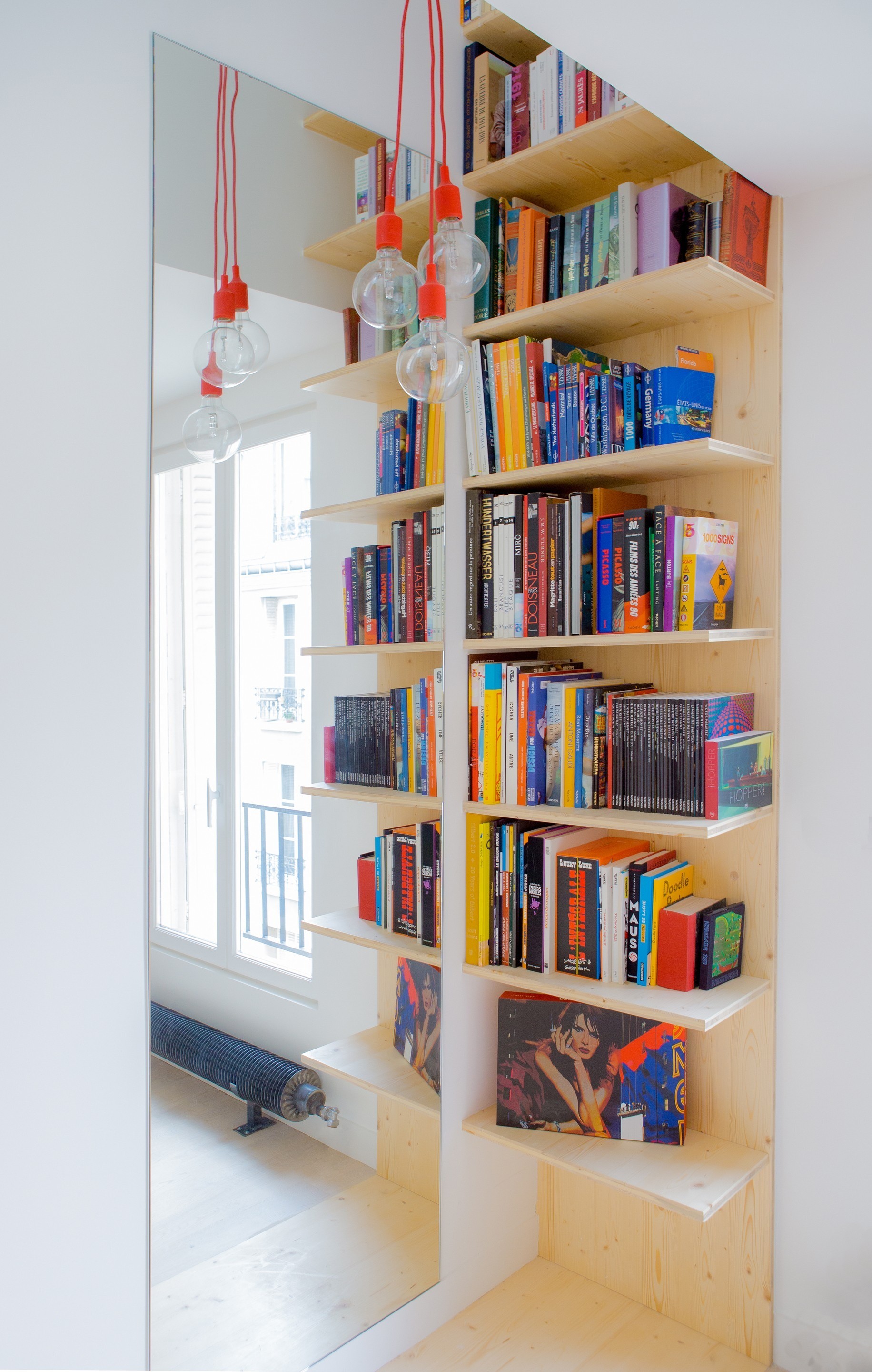 Tận dụng góc phòng để bố trí kệ sách mở nhiều tầng, những cuốn sách vừa thú vị vừa nhiều màu sắc cũng góp phần làm cho căn hộ trở nên thu hút.
