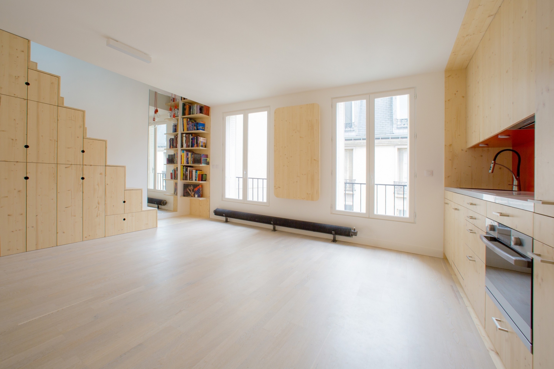 Căn hộ sử dụng gam màu trắng thanh lịch và nội thất bằng vật liệu gỗ sáng màu để tạo cảm giác cho không gian rộng hơn so với diện tích thật.