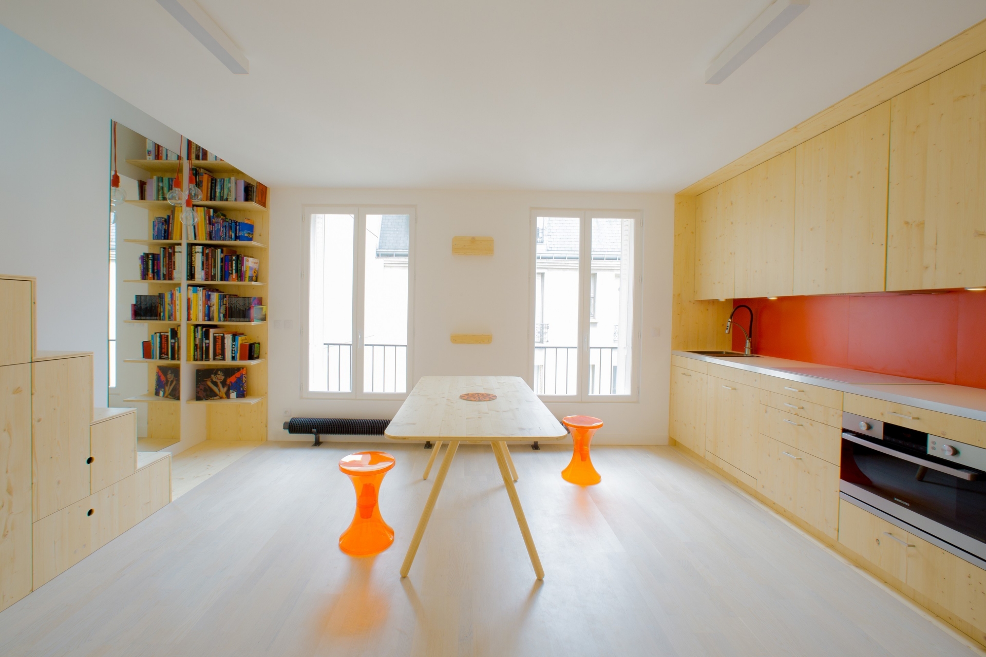 Chiếc bàn bằng gỗ tươi sáng kết hợp cùng ghế ngồi màu cam nổi bật, vừa là “phòng ăn” đồng thời cũng trở thành “phòng khách” siêu tiện lợi.