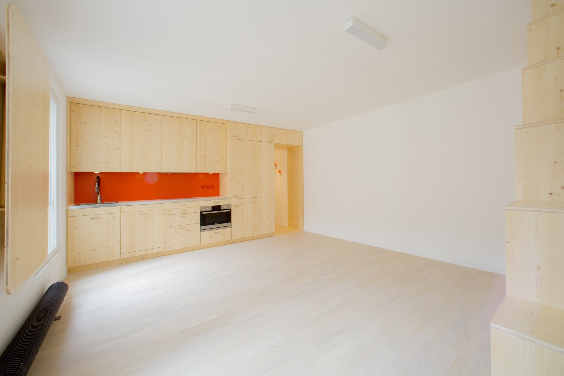 Phòng bếp được thiết kế kiểu chữ I cực kỳ phù hợp với những căn hộ có diện tích nhỏ. Backsplash sử dụng gam màu cam khiến khu vực nấu nướng sáng bừng hơn hẳn.