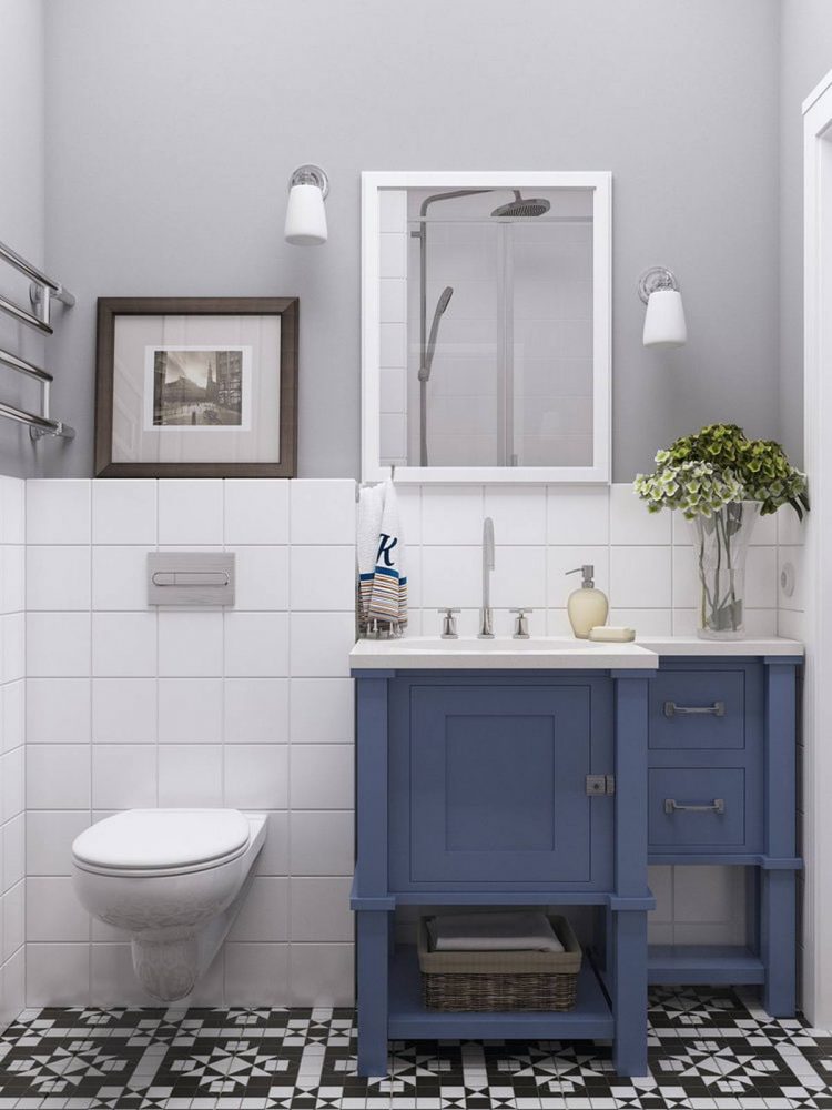 Nội thất phòng tắm có thiết kế nhỏ gọn, từ bồn toilet gắn tường, tủ lưu trữ kết hợp bồn rửa màu xanh lam cho đến gạch bông lát sàn nổi bật trên nền phông nền trắng.