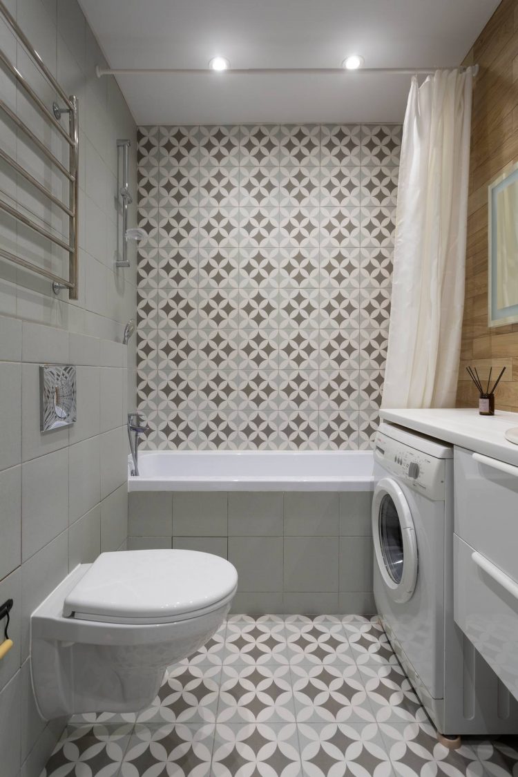 Phòng tắm nhỏ nhưng bắt mắt bởi sàn nhà và tường khu vực bồn tắm ốp gạch bông sắc màu trang nhã. Bức tường gỗ đối diện với tường gạch trắng tạo cảm giác tương phản nhẹ nhàng. Bồn toilet cũng thiết kế gắn tường để tiết kiệm diện tích.