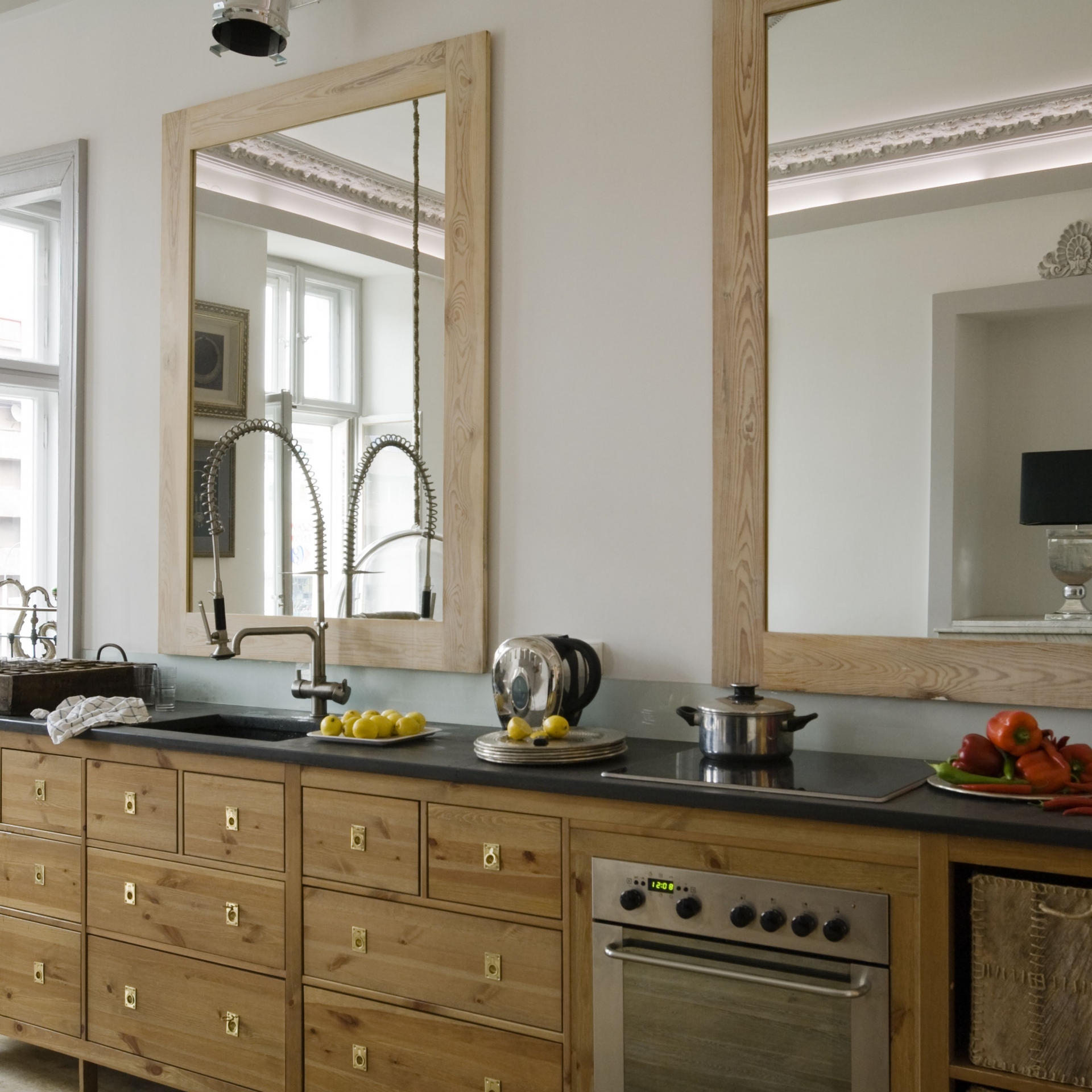 Nếu phòng bếp của bạn đủ dài và rộng thì hoàn toàn có thể kết hợp một lúc 2-3 tấm gương trên tường bếp với khoảng cách hợp lý để “nhân rộng” không gian, giúp cho khu vực nấu nướng đã rộng rãi càng thêm phần thoáng đãng và đẹp mắt.