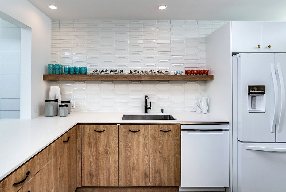 Giữa phông nền màu trắng hoàn toàn từ bức tường cho đến thiết bị nhà bếp thì hệ thống tủ lưu trữ gỗ với tay nắm màu đen đã trở thành điểm nhấn lôi cuốn nhất.
