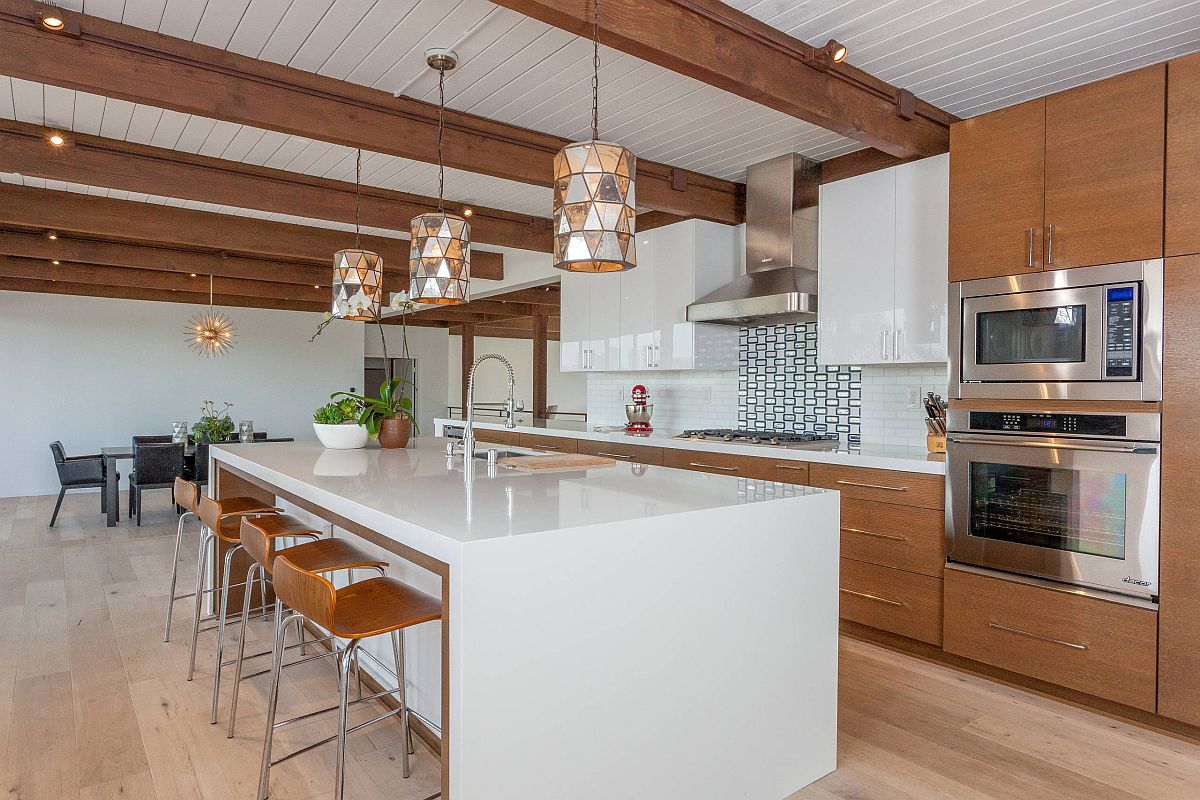 Tủ bếp bằng gỗ đậm màu kết hợp với dầm gỗ và ghế ăn tương đồng tạo nên sự đẹp mắt trong căn bếp lựa chọn phong cách Mid-century Modern.