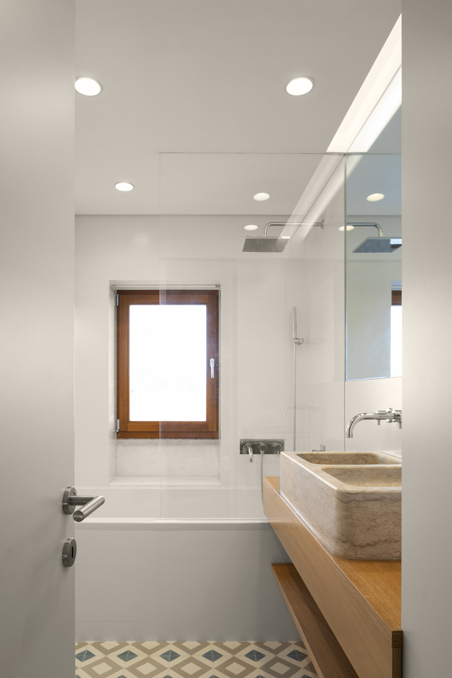 Phòng tắm sử dụng hệ thống đèn âm trần giúp nâng cao trần nhà kết hợp với cửa kính trong suốt cho cái nhìn tươi sáng khắp không gian thư giãn.
