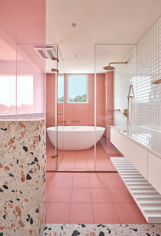Phòng tắm đẹp không thua gì một spa thư giãn với sàn nhà lát gạch hồng, kéo dài lên đến tận bức tường . Khu vực buồng tắm và toilet được phân vùng bằng gạch ốp tường 2 màu hồng, trắng.
