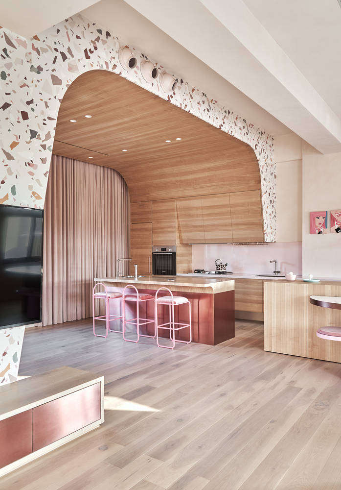 Phòng bếp như được bao bọc dưới mái vòm bắt mắt, nội thất gỗ mộc mạc kết hợp những chi tiết màu hồng nhiều sắc thái ở đảo bếp và ghế ăn quầy bar sang chảnh.