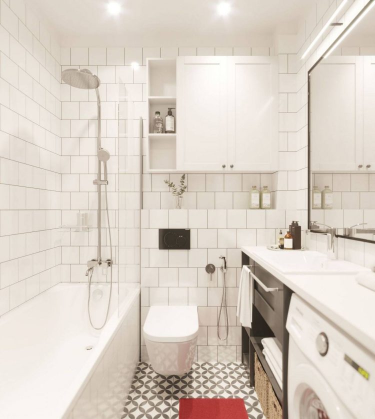 Phòng tắm gam màu trắng chủ đạo với thiết kế tủ đóng kín trên cao và hốc tường để lưu trữ đồ dùng. Tấm thảm chùi chân màu đỏ nổi bật trên sàn gạch bông cổ điển.