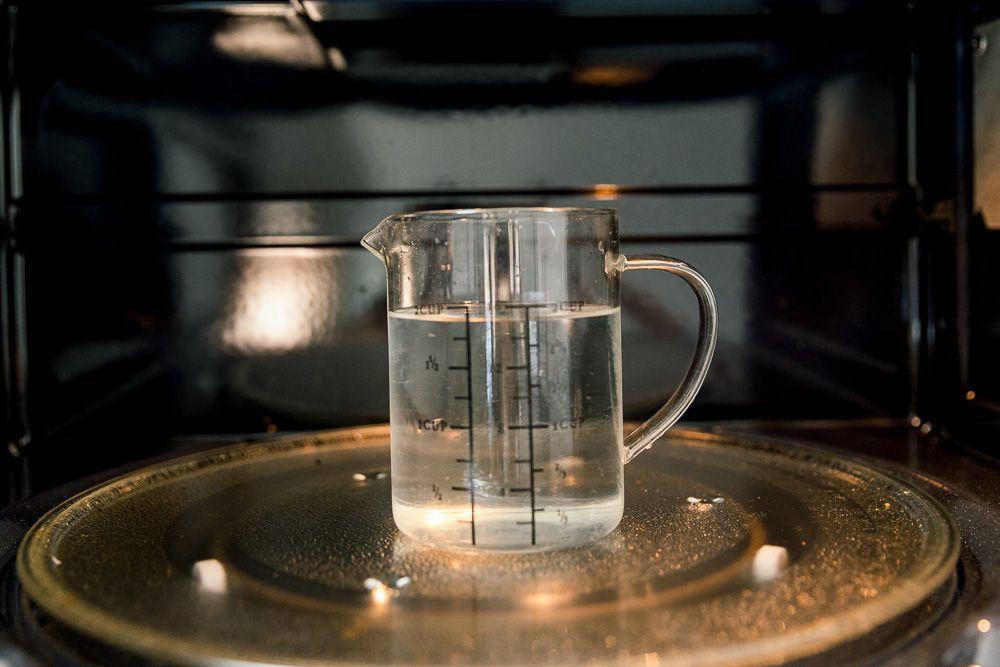 Để giúp cho quá trình vệ sinh dễ dàng, hãy cho 1/4 cốc nước chanh hòa vào 2 cốc nước trong tô/cốc thủy tinh và cho vào lò vi sóng.