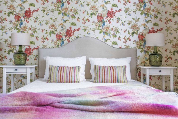Một cặp bàn trắng nhỏ 2 tầng sử dụng như táp đầu giường đặt đối xứng hai bên giường ngủ, cùng với đó là cặp đèn ngủ với phần thân đèn thủy tinh xanh lá tuyệt đẹp.