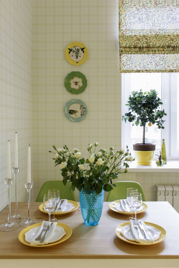 Trên bàn trang trí chân đựng nến, lọ hoa thủy tinh xanh lam nhạt. Bức tường được tô điểm bởi 3 chiếc đĩa hoa văn đẹp mắt cùng 3 màu chủ đạo xuất hiện ở phòng ăn.