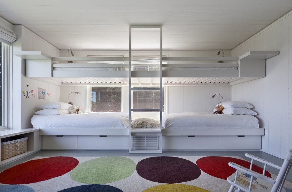 Chỉ một khu vực cạnh ô cửa sổ đầy nắng ấm mà chủ nhân có thể thiết kế đến 4 chiếc giường dành cho các thành viên. Mẫu giường tầng màu trắng với thiết kế tối giản, đường nét gọn gàng tươi sáng phảng phất nét kiến trúc đương đại. Bên cạnh đó, tấm thảm trải sàn rực rỡ sắc màu cũng giúp cho không gian vui tươi, sống động hơn.
