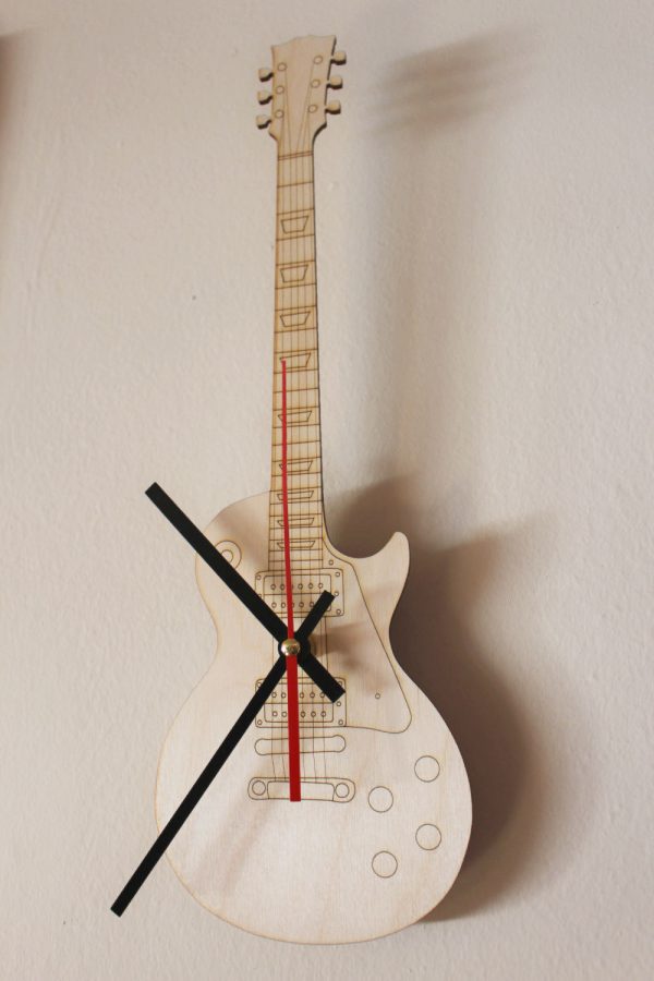 Gỗ bạch dương được cắt bằng laser đã tạo nên chiếc đồng hồ treo tường độc đáo có hình dáng cây đàn guitar với những chiếc kim đỏ - đen nổi bật trên nền gỗ sáng màu.