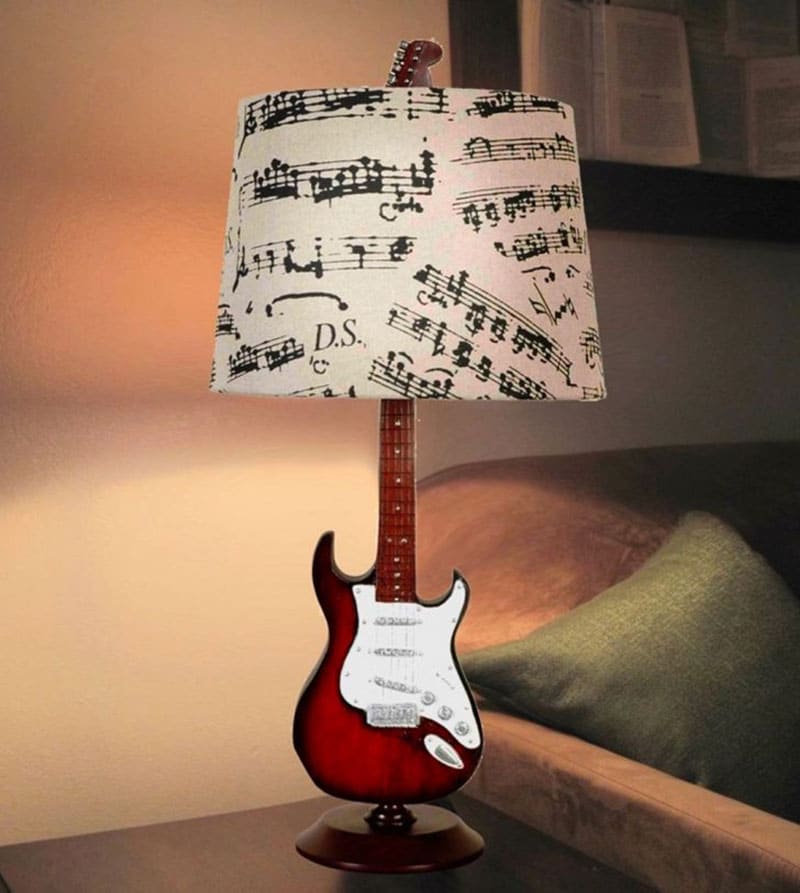 Bạn đoán xem nhà thiết kế sẽ tạo nên món đồ gì trong phòng ngủ? Đó chính là chiếc đèn với phần thân là hình ảnh đàn guitar còn chụp đèn là bản nhạc trắng - đen cực vintage.