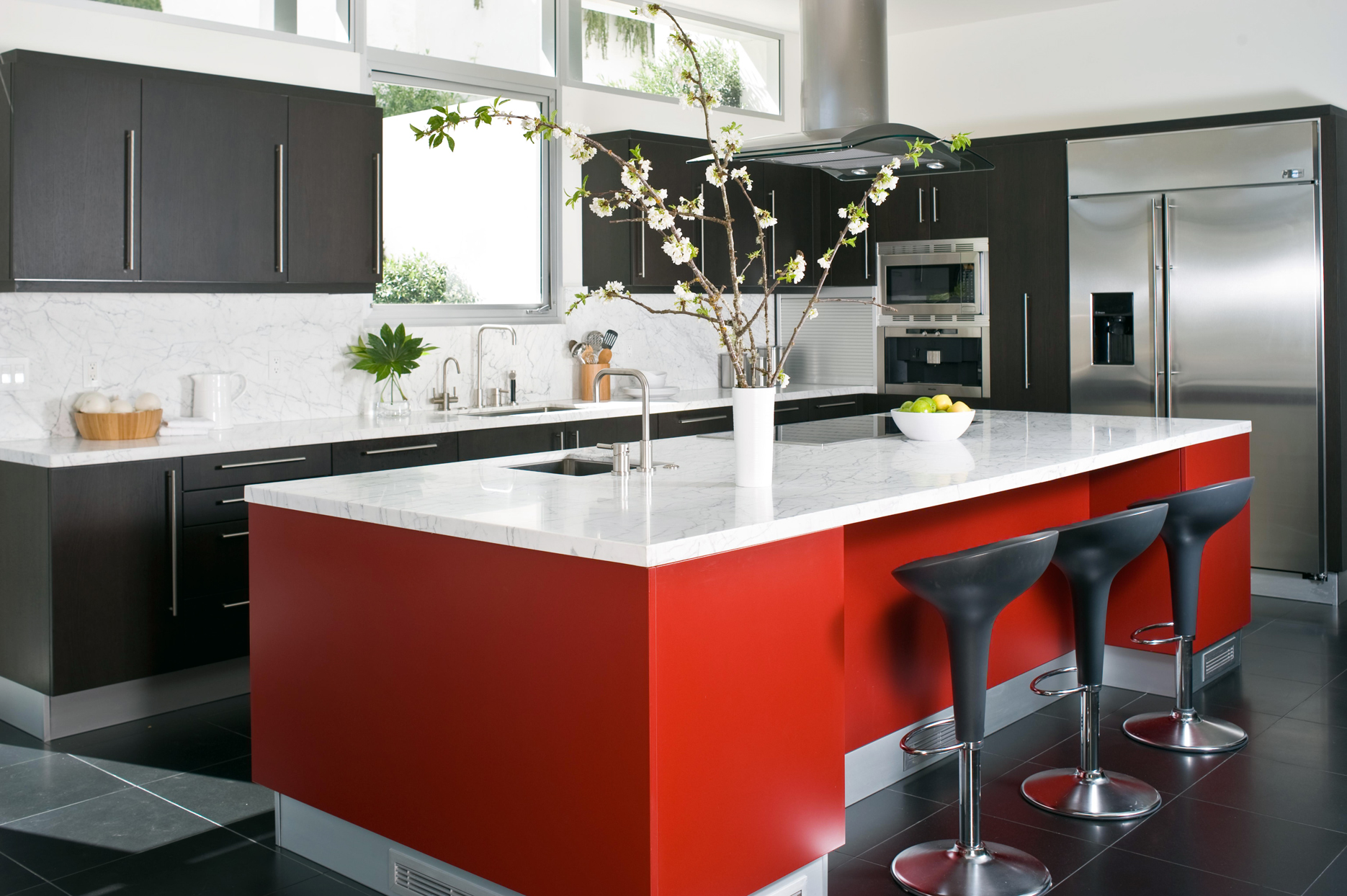 Phòng bếp này là minh chứng cho sự kết hợp hoàn hảo giữa 2 gam màu trắng - đen cổ điển và sắc đỏ nồng nàn tạo nên một không gian vừa cổ điển vừa hiện đại. Toàn bộ tủ bếp sử dụng màu đen, mặt bàn và backsplash ốp đá cẩm thạch trắng. Duy nhất đảo bếp có gam màu đỏ nhưng lại trở thành trung tâm của sự chú ý hơn cả.