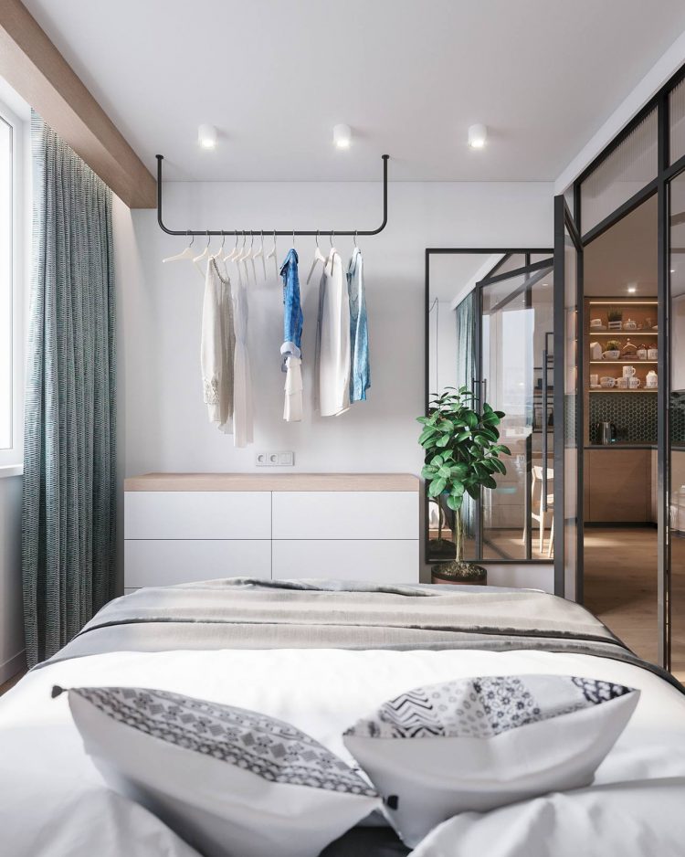 Phía cuối giường, thay vì sử dụng tủ quần áo đứng, các nhà thiết kế đã chọn kiểu thanh treo ngang để giúp căn phòng rộng rãi hơn. Chiếc tủ màu trắng mặt gỗ bên dưới đóng vai trò lưu trữ cho phòng ngủ.