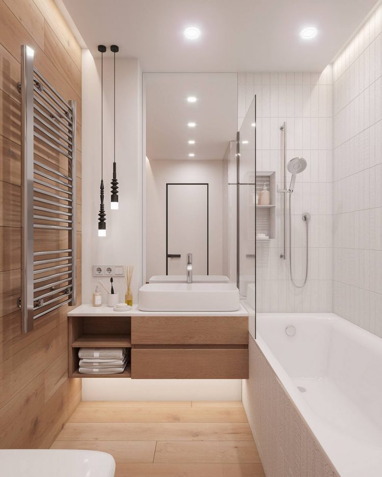 Hệ thống tủ lưu trữ kết hợp bồn rửa gắn tường nhằm giải phóng diện tích mặt sàn. Buồng tắm được phân cách bằng cửa kính trong suốt kết hợp gương treo tường cho không gian rộng hơn thực tế.