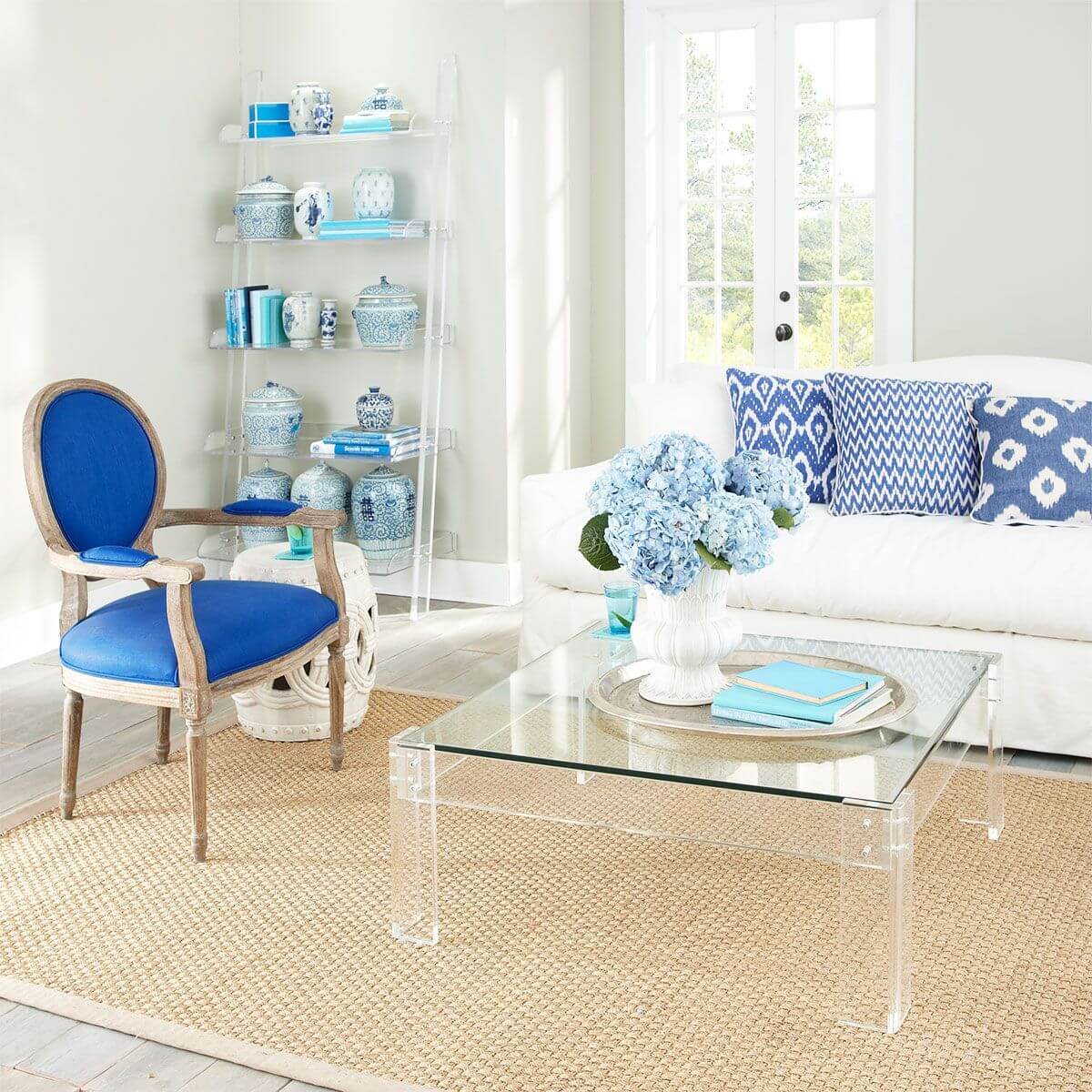Nội thất acrylic thực sự tuyệt vời vì chúng không cản trở tầm nhìn của chúng ta, chẳng hạn như ở phòng khách này, cả bàn nước và kệ hình thang đều trở thành phông nền cho phụ kiện xanh lam tỏa sáng.