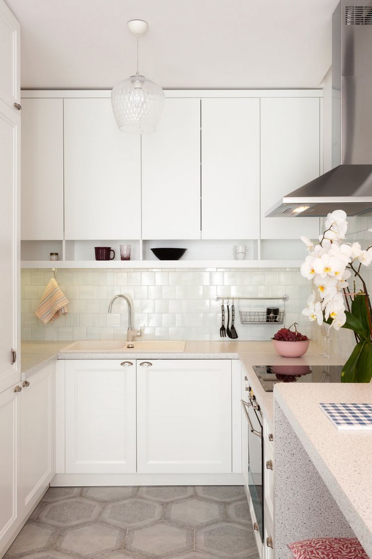 Phía trong cùng là khu vực dành cho phòng bếp tiện nghi với gam màu trắng chủ đạo của hệ tủ bếp trên và dưới, backsplash ốp gạch sáng bóng.