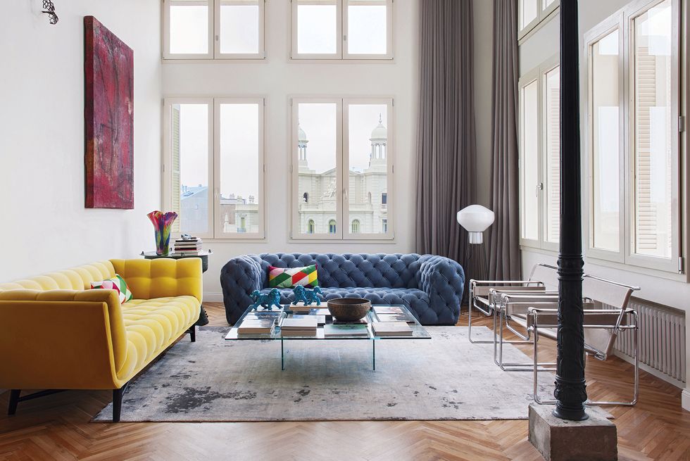 Một chiếc ghế sofa màu xanh lam đậm mang cảm giác yên bình, vững chãi. Một chiếc ghế màu vàng mù tạt tươi sáng, trẻ trung. Khi cả hai được kết hợp cùng nhau không hề gây cảm giác lạc điệu, trái lại còn bổ sung cho nhau tạo nên vẻ đẹp cá tính cho phòng khách của căn hộ.
