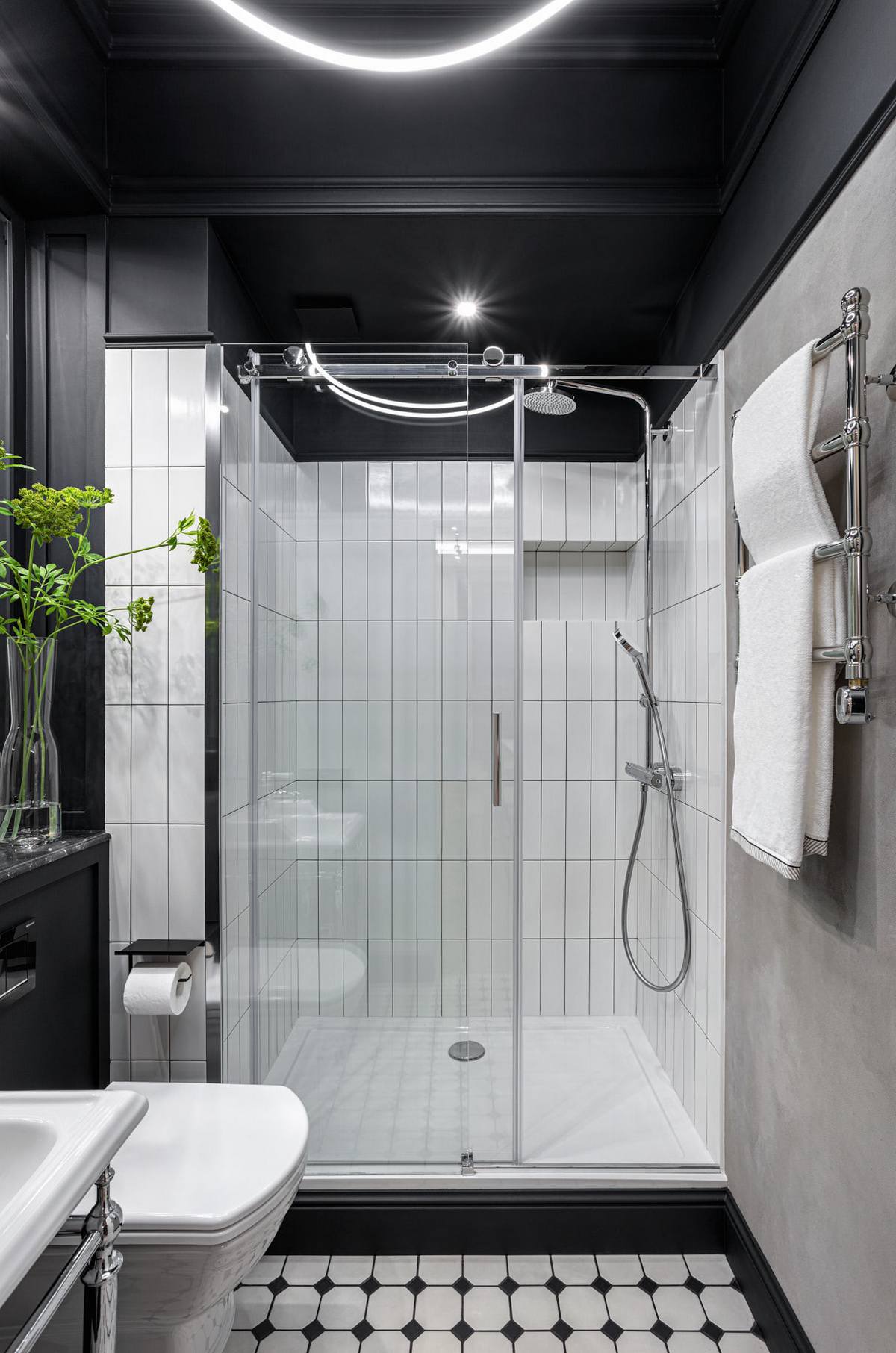 Khu vực phòng tắm vẫn 'trung thành' với hai gam màu đen trắng bằng cách sử dụng sơn trần màu đen, tường ốp gạch trắng và sàn nhà hình ô vuông trắng đen xen kẽ tạo cảm giác tương phản.