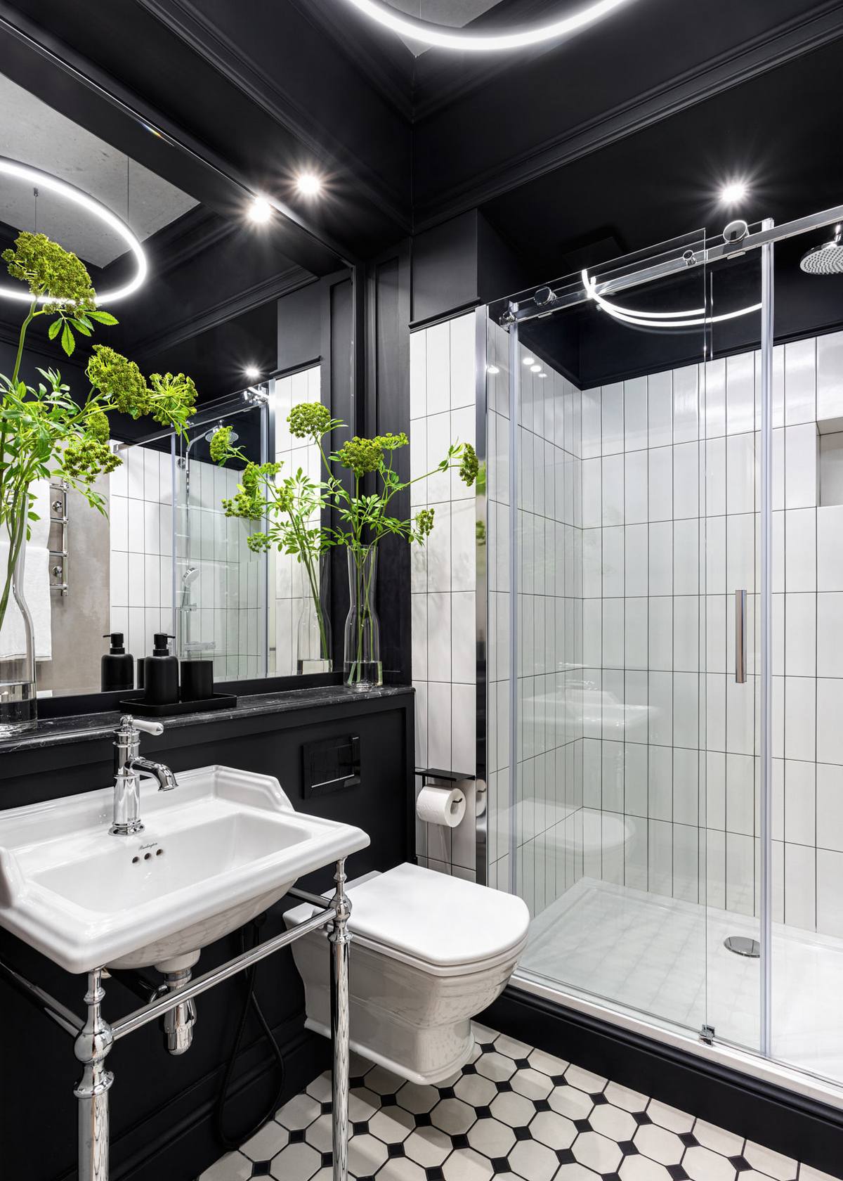 Bồn toilet gắn tường giúp giải phóng diện tích mặt sàn đồng thời vệ sinh dễ dàng hơn. Tấm gương to gần như ốp toàn bộ bức tường trên bồn rửa kết hợp với cửa kính trượt trong suốt phân vùng buồng tắm và nhà vệ sinh trông cực kỳ rộng rãi.
