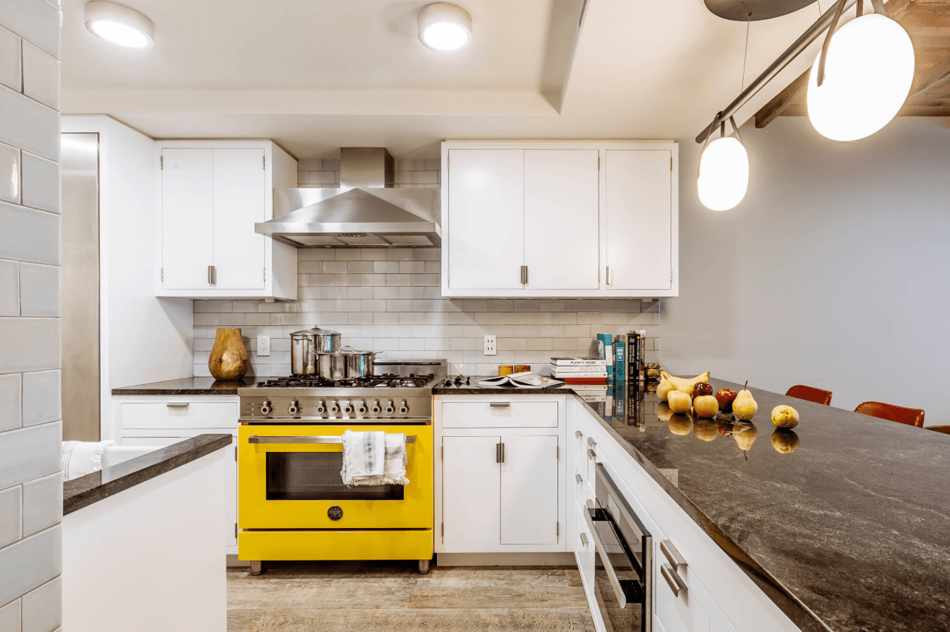 Phòng bếp này chỉ sử dụng màu vàng như một điểm nhấn nhá để căn phòng được chiếm lĩnh bởi sắc trắng không rơi vào cảm giác lạnh lẽo. Màu vàng được sơn cho lò nướng bên bố trí bên dưới bếp nấu khiến ai bước vào đều sẽ hướng sự chú ý về nó.
