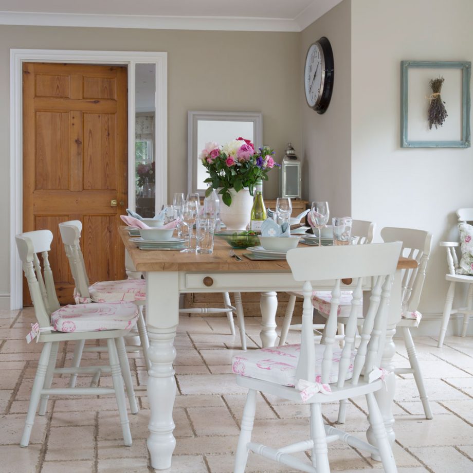 Phòng ăn thiết kế theo phong cách đồng quê mộc mạc với sàn gạch truyền thống, sơn tường màu be đậm, bộ bàn ăn bằng gỗ với lớp sơn trắng tinh khôi cùng mặt bàn gỗ tự nhiên hài hòa.
