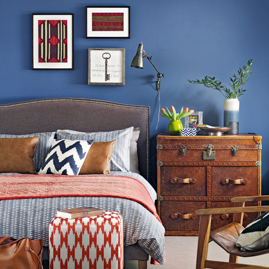 Những ai khéo trong việc phối hợp màu sắc có thể tận dụng màu xanh làm phông nền để nội thất trở nên lôi cuốn. Chẳng hạn như phòng ngủ này, chiếc tủ màu da bò kiểu cổ điển, giường xám và những chi tiết màu đỏ cam trông quyến rũ vô cùng.