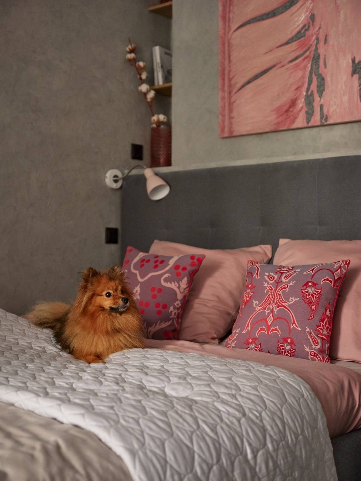 Căn phòng sử dụng màu xám và hồng làm chủ đạo, hòa quyện giữa vẻ thanh lịch của màu xám và điệu đà của sắc hồng. Khu vực đầu giường được thiết kế vững chắc.