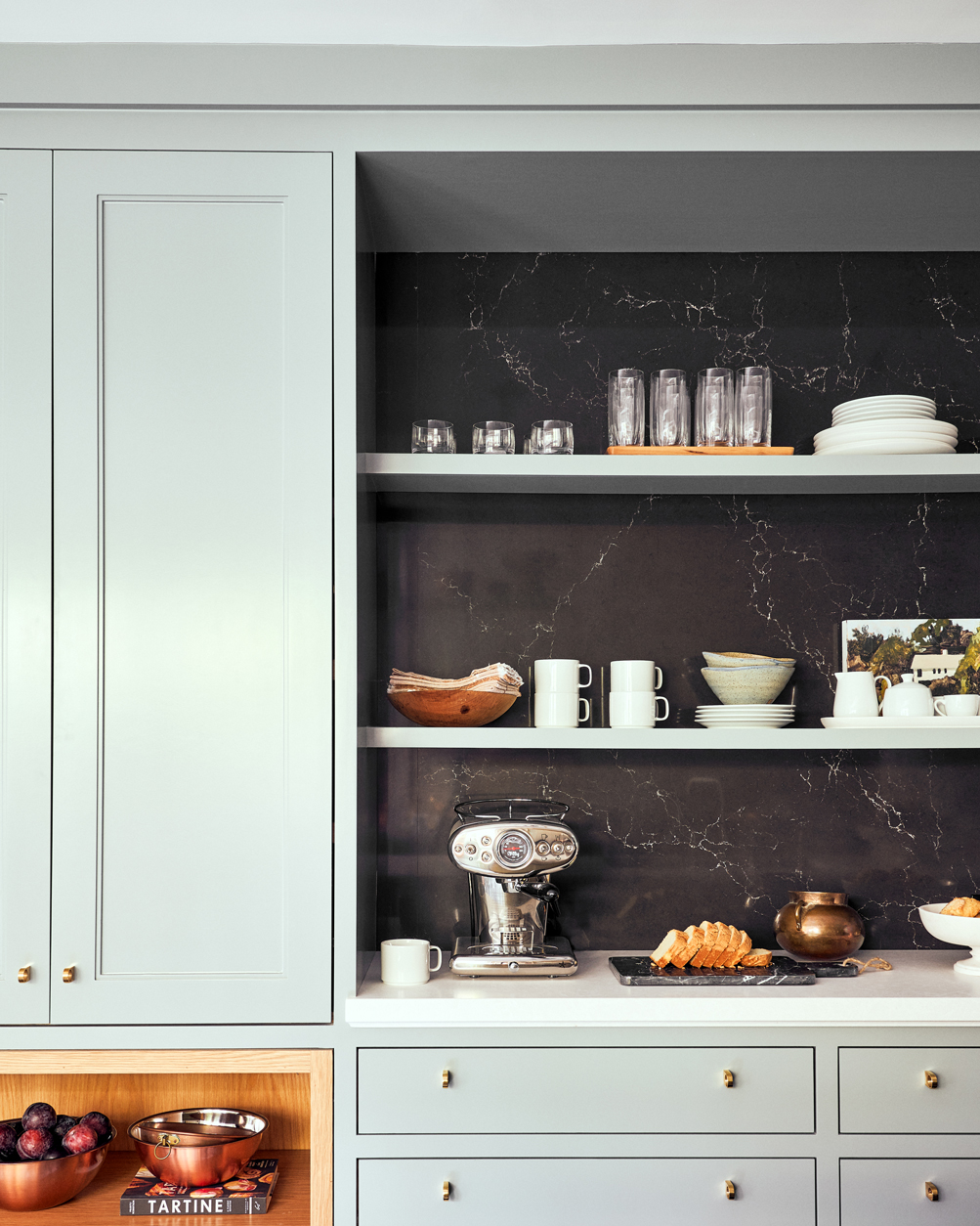 Tủ bếp sơn màu xanh pastel với một khoảng tường màu đen tạo phông nền hoàn hảo cho những bộ đồ dùng ăn uống trở nên nổi bật hơn.