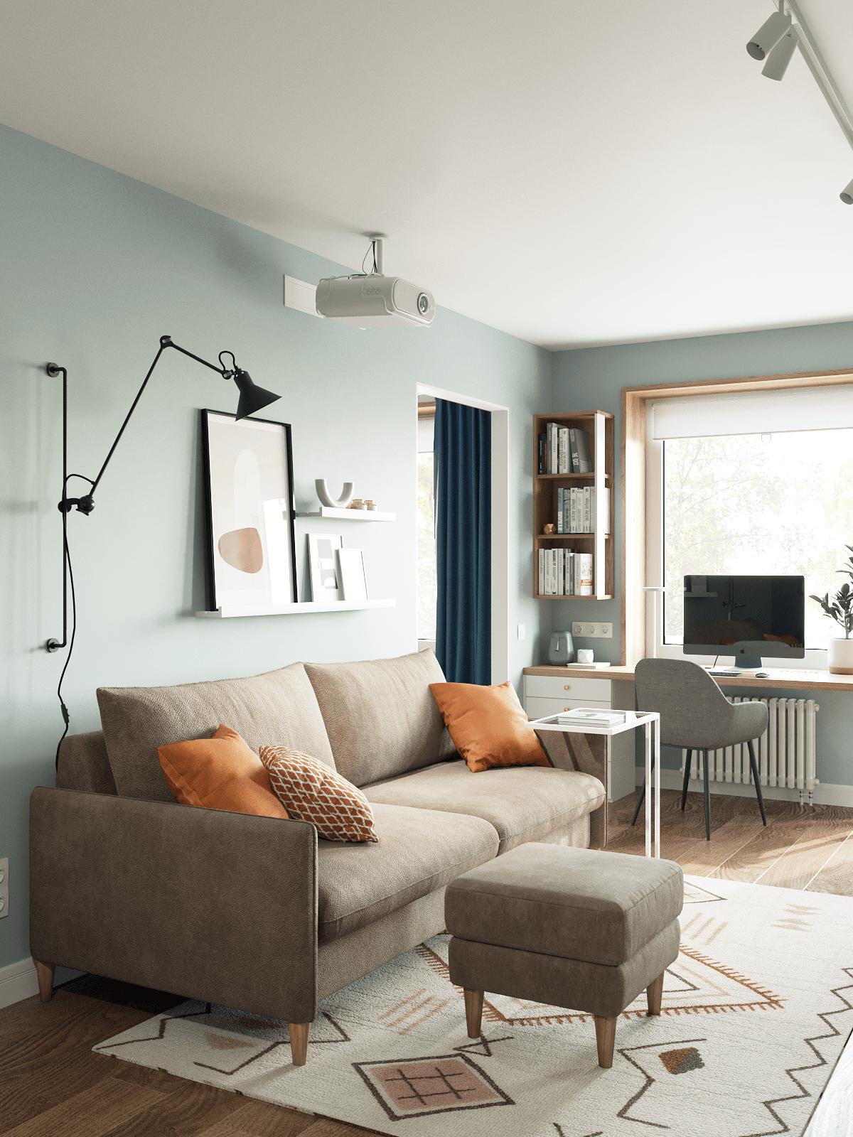 Phòng khách với bộ ghế màu be đậm êm ái, nổi bật những chiếc gối tựa màu cam ấm áp. Chiếc đèn gắn tường bố trí sau sofa, có thể điều chỉnh độ cao để cung cấp ánh sáng cho gia chủ.