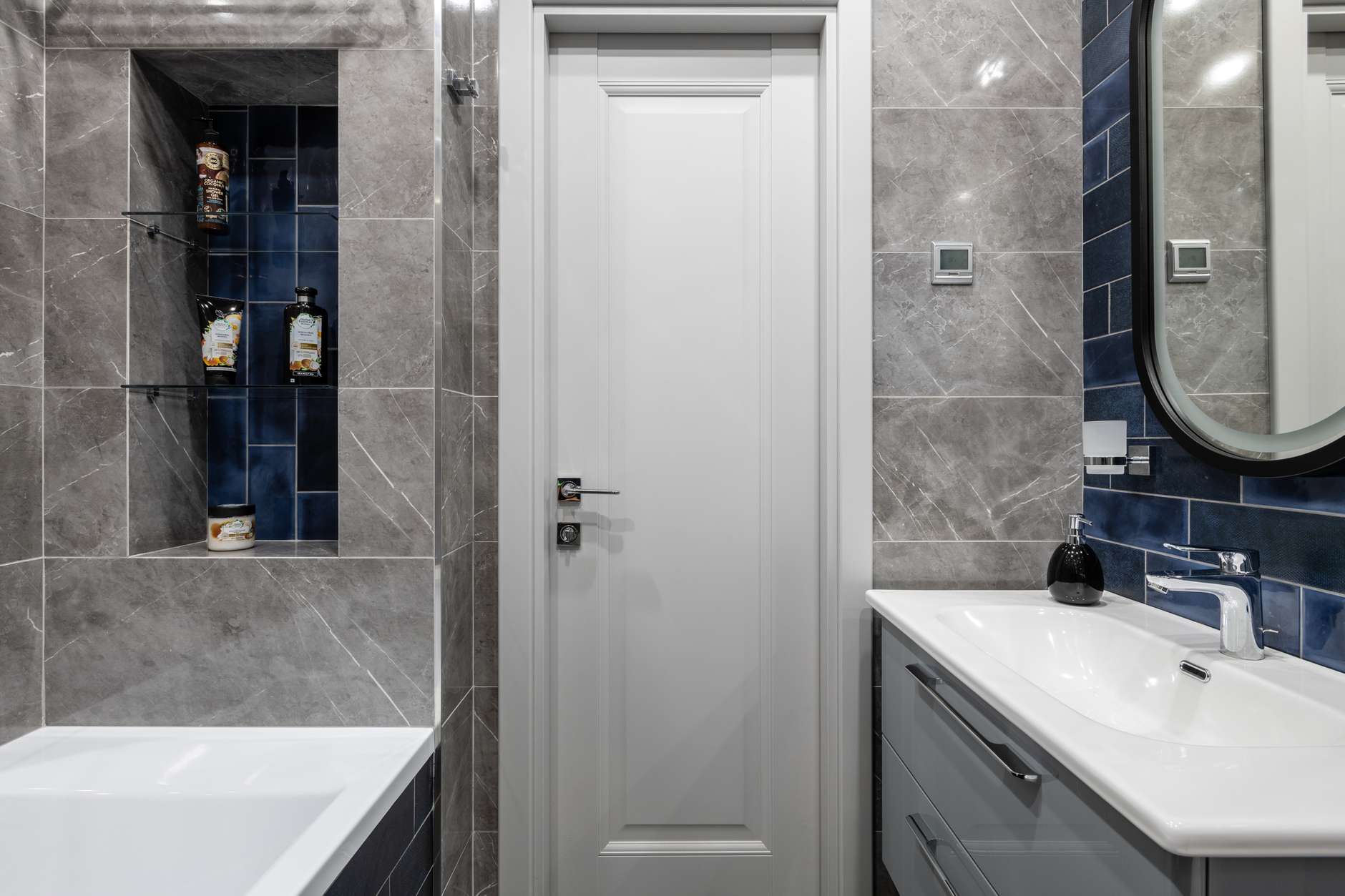 Phòng tắm là sự kết hợp giữa màu trắng thanh lịch, sắc xám sang trọng và gam màu xanh lam đậm cực kỳ thời trang và nổi bật.