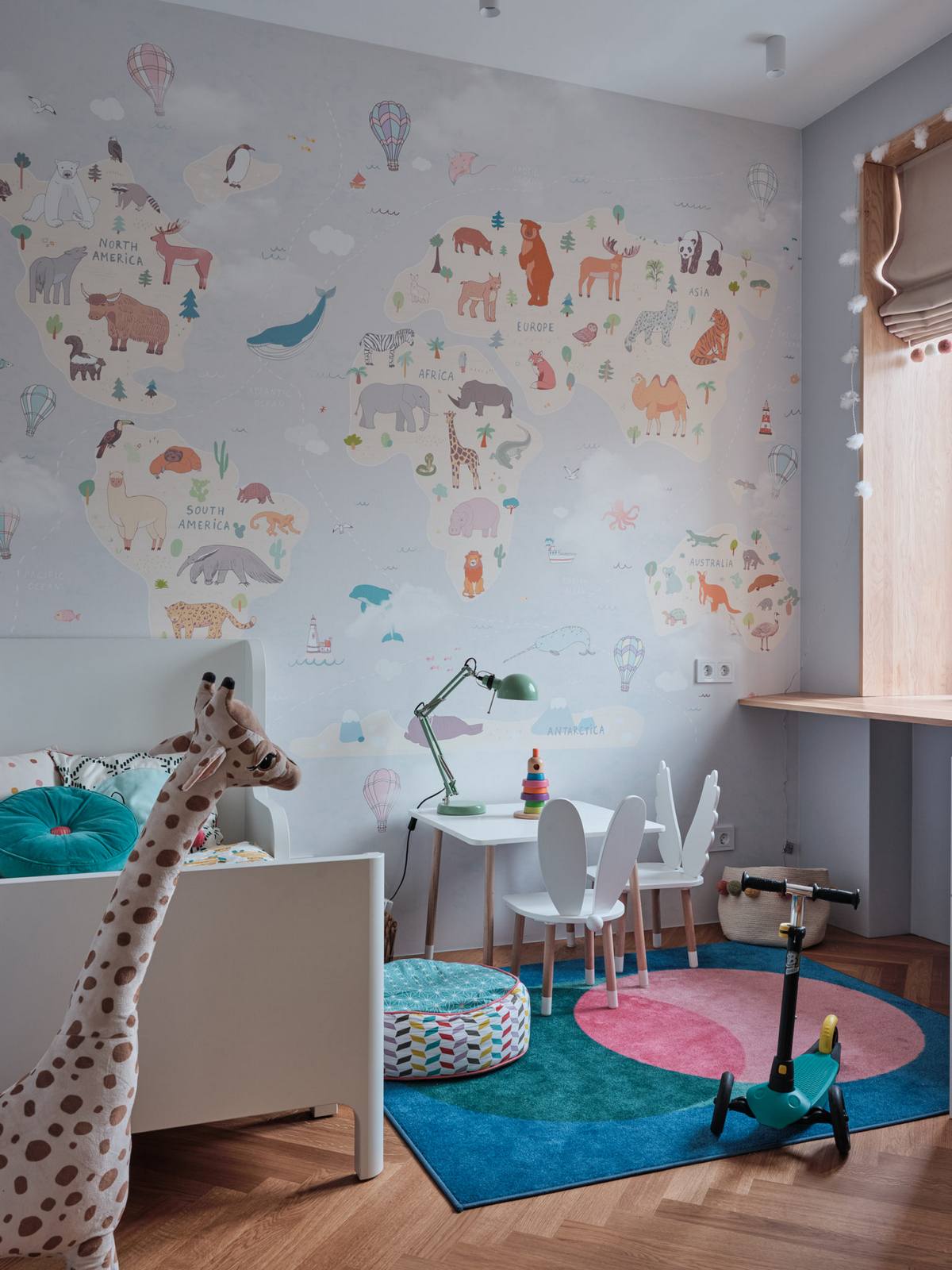 Phòng ngủ của cô con gái nhỏ được thiết kế cực kỳ dễ thương với giấy dán tường chủ đề động vật xinh xắn. Chú hươu cao cổ bằng bông hay tấm thảm trải sàn và ghế đôn sắc màu rực rỡ.