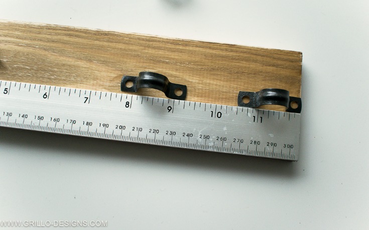 Đặt những chiếc bát sắt omega lên tấm gỗ, dùng thước đo khoảng cách và dùng bút chì đánh dấu lại.