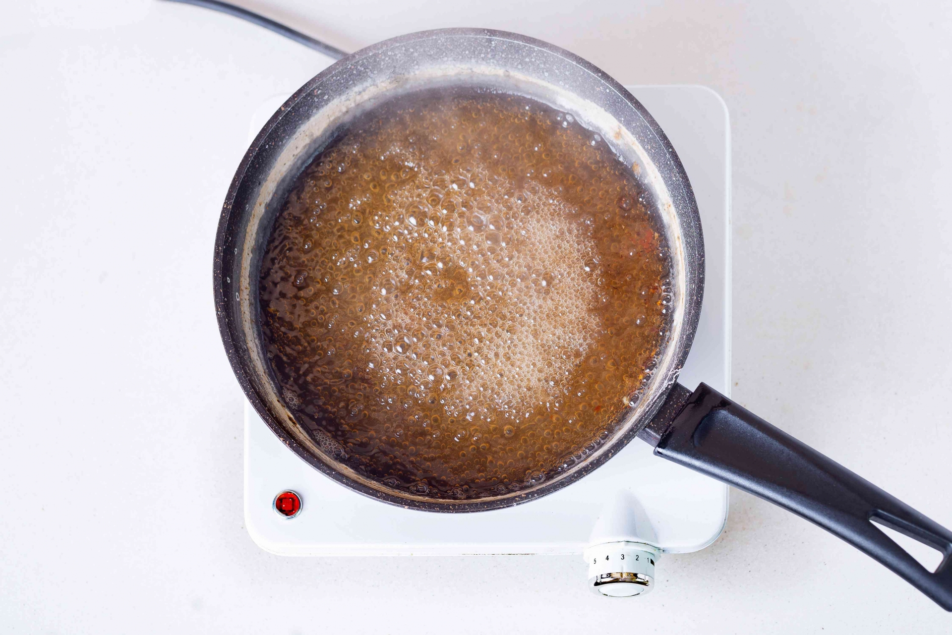 Đặt chảo lên bếp và đun sôi dung dịch baking soda hòa với nước. 