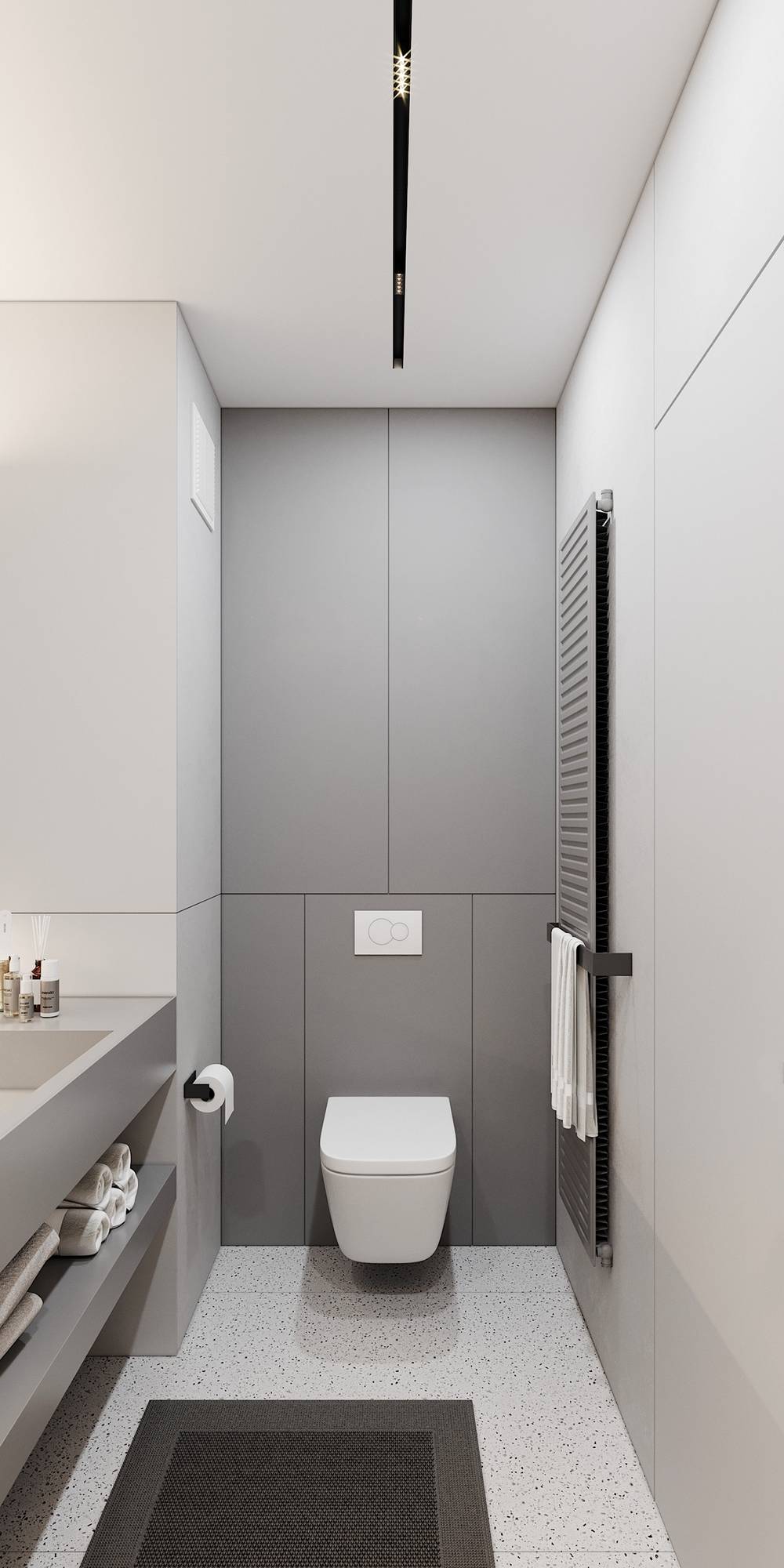 Sàn phòng tắm lát gạch với họa tiết đơn giản, kết hợp thảm chống trượt an toàn. Toilet gắn tường và giá treo khăn tắm giúp giải phóng diện tích sàn hiệu quả.