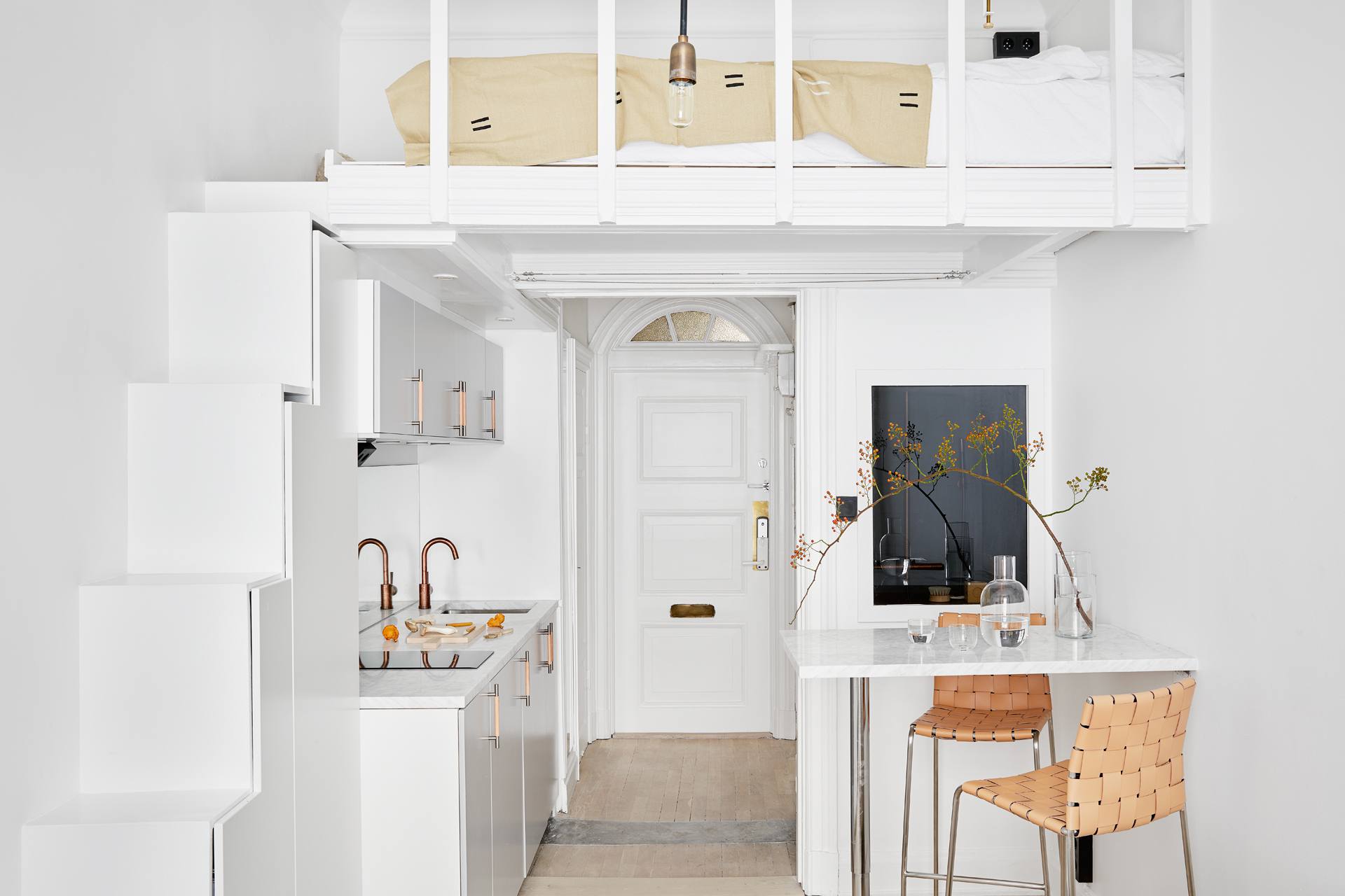 Căn hộ studio nhỏ xinh với gam màu trắng thanh lịch theo phong cách Scandinavian. Khu vực phòng ngủ được bố trí trên gác lửng với những bậc thang tích hợp đồng thời tủ lưu trữ tiện lợi cho nhà luôn gọn gàng.