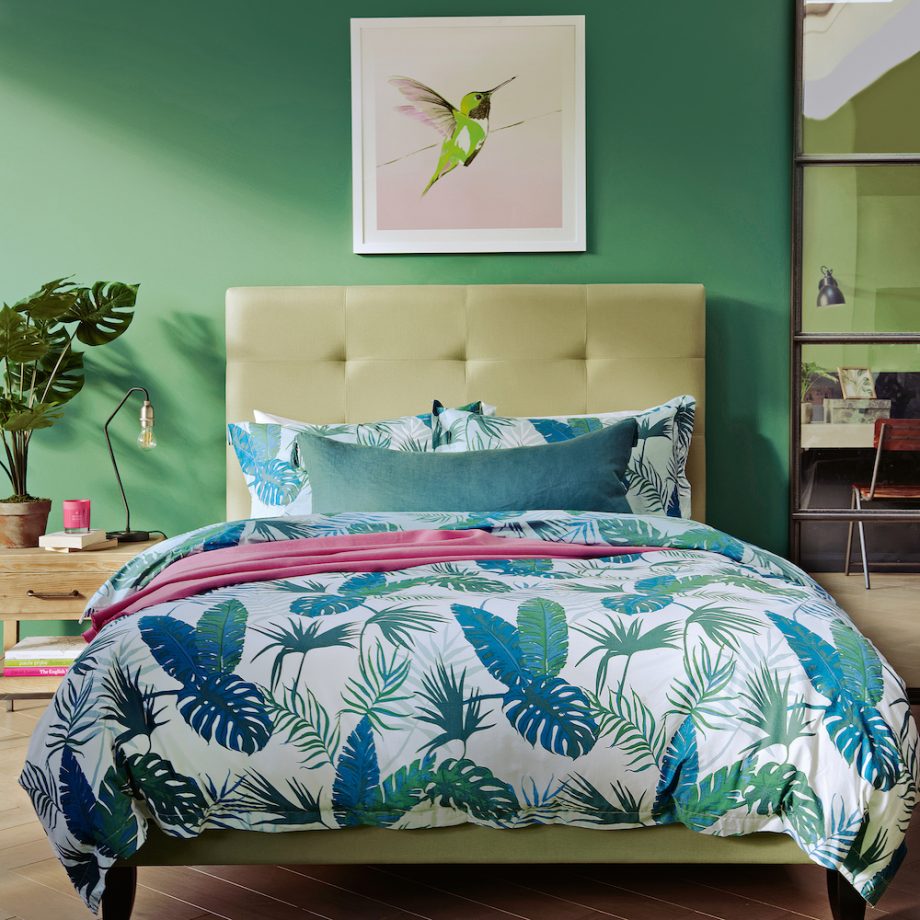 Chẳng những chủ nhân lựa chọn các sắc thái xanh lá mà còn pha trộn cả màu xanh lam trên bộ chăn ga gối mang cảm hứng nhiệt đới vào phòng ngủ.