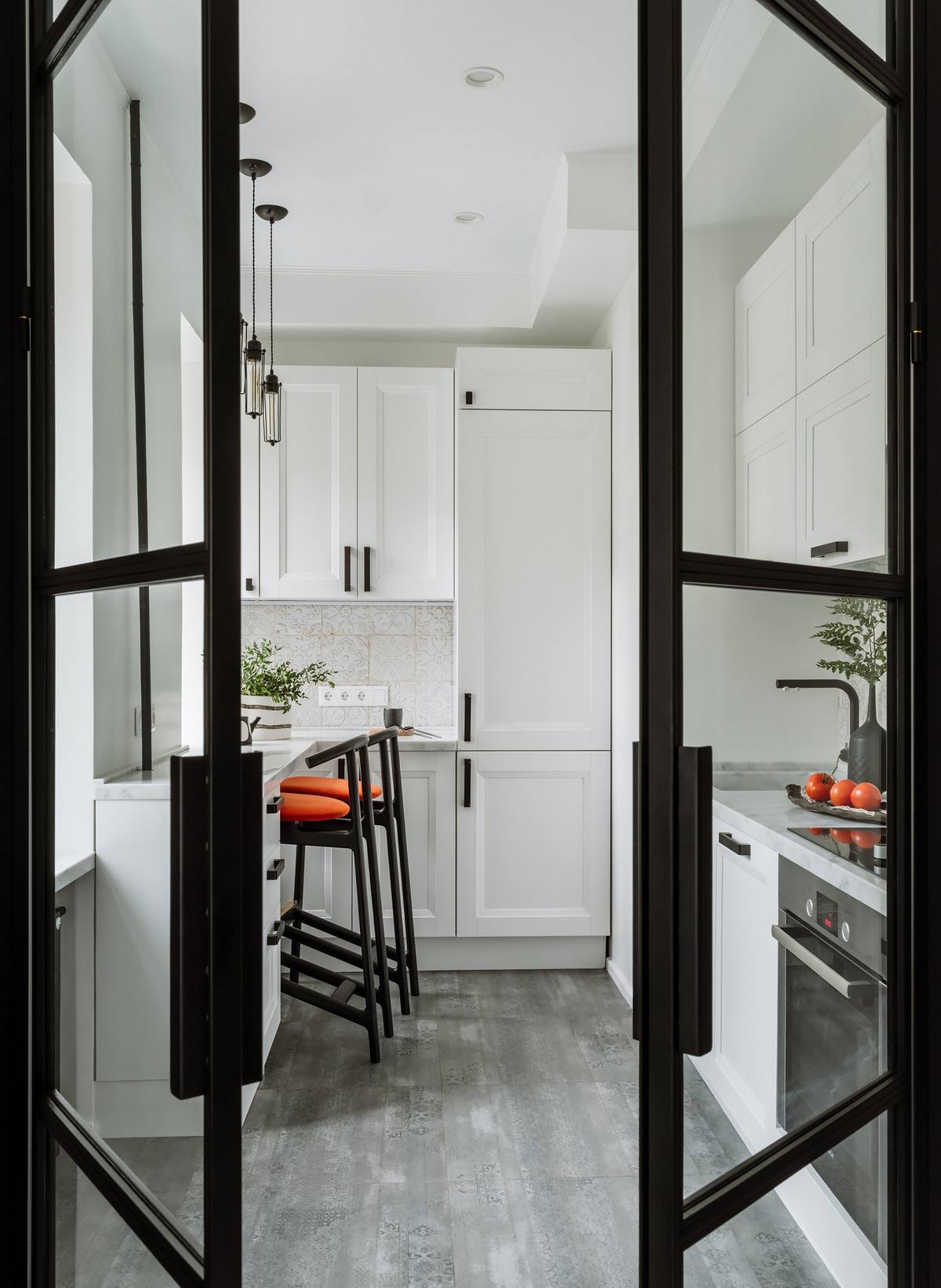 Phòng bếp được bố trí ở một không gian riêng, tách biệt với phòng khách bằng cửa kính viền khung màu đen kiểu Pháp cổ điển.