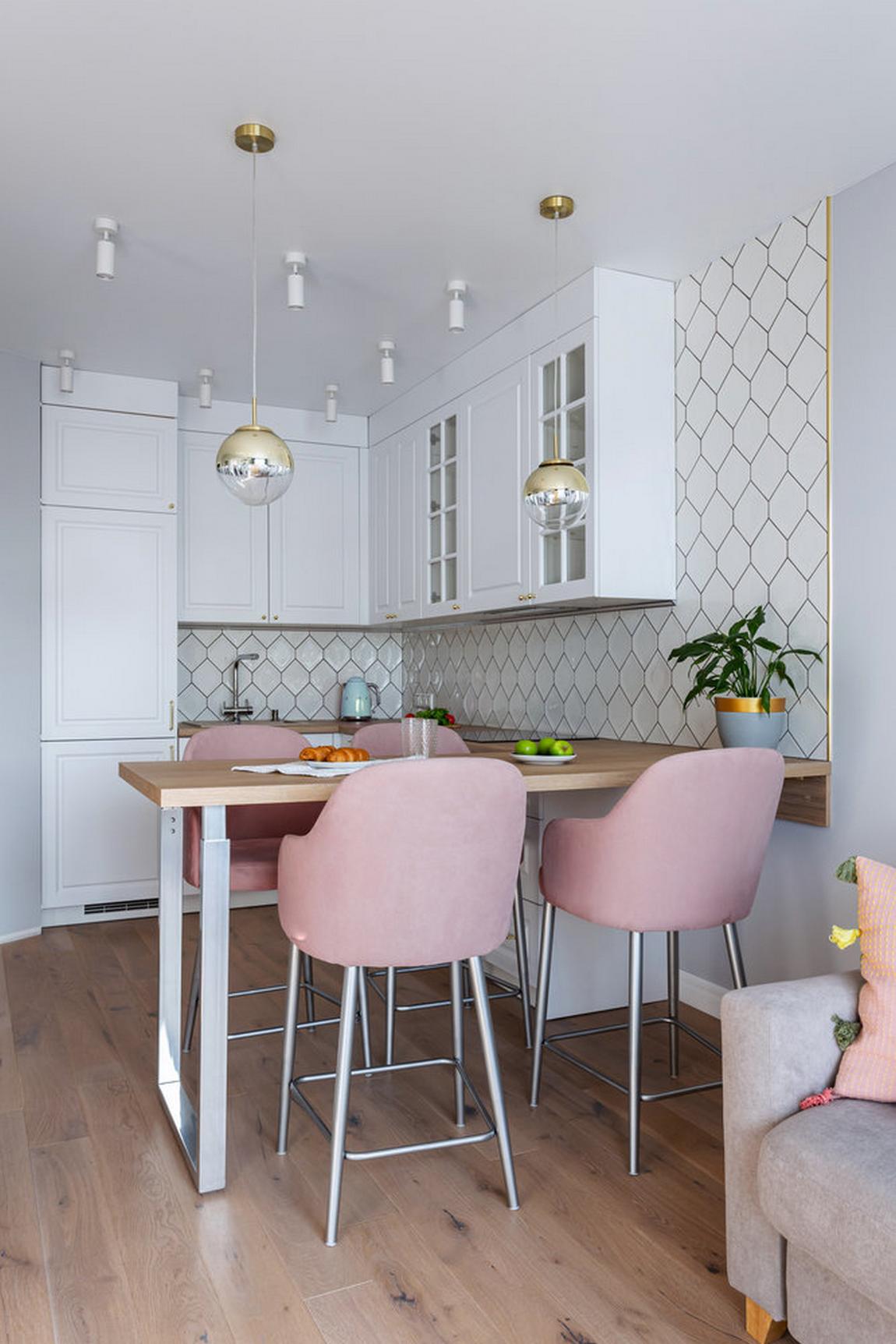 Từ góc chụp này, bạn sẽ thấy khu vực ăn uống được bố trí ở vị trí giữa phòng khách và phòng bếp. Bếp được thiết kế kiểu chữ L phù hợp với cấu trúc căn  hộ. Tủ bếp màu trắng tạo sự tương phản nhẹ nhàng trên màu tường sơn xám nhạt.