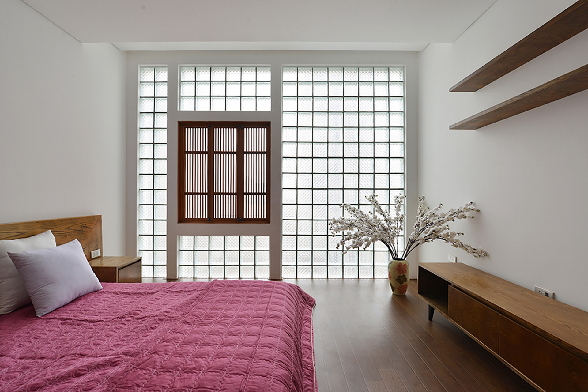 Phòng ngủ ngọt ngào và nữ tính với sắc hồng - trắng, nội thất gỗ thấp sàn cùng những chi tiết trang trí như lọ hoa xinh đẹp. 