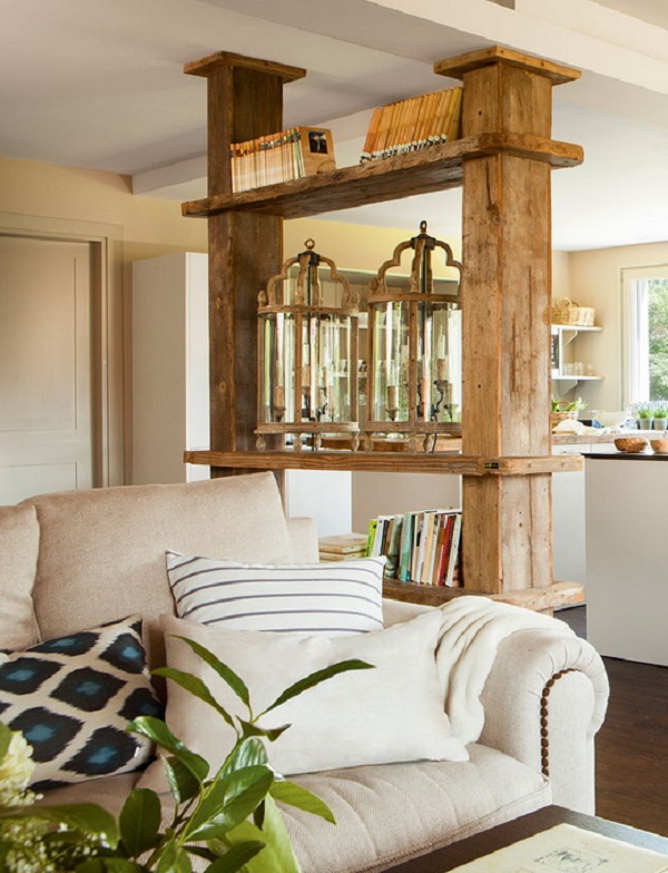 Vì thiết kế mở loại bỏ các bức tường thô cứng nên một chiếc kệ mở bằng gỗ với cấu trúc chắc chắn được thiết lập để phân vùng phòng khách và bếp.