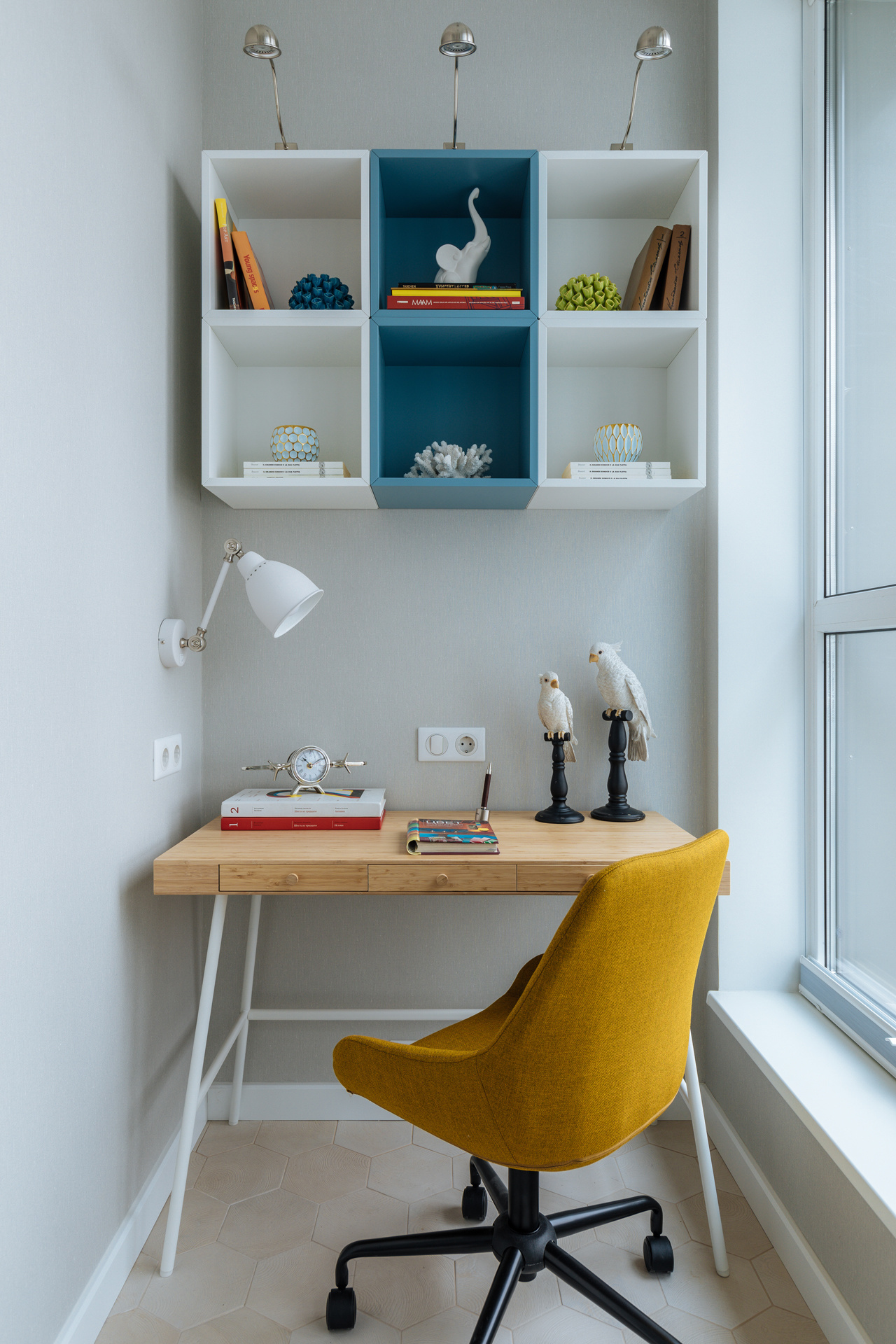 Góc làm việc tại gia đơn giản nhưng tiện nghi, được bố trí tại góc logia của căn hộ nhỏ. Chiếc bàn gỗ mộc mạc, ghế xoay màu vàng mù tạt, kết hợp với bộ kệ treo tường trắng - xanh lam từ thương hiệu IKEA tạo nên khu vực làm việc tiện nghi, đẹp mắt.