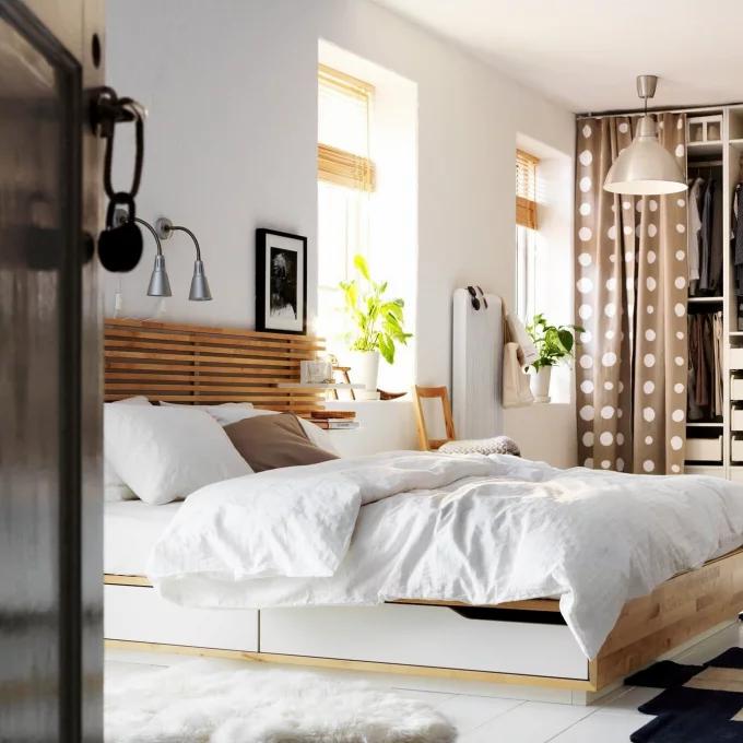 Phòng ngủ nhẹ nhàng với gam màu trắng thanh lịch cùng những ô cửa sổ đầy nắng ấm, kết hợp với phần đầu giường kiểu lam gỗ sáng màu “tone sur tone” với rèm cuốn.