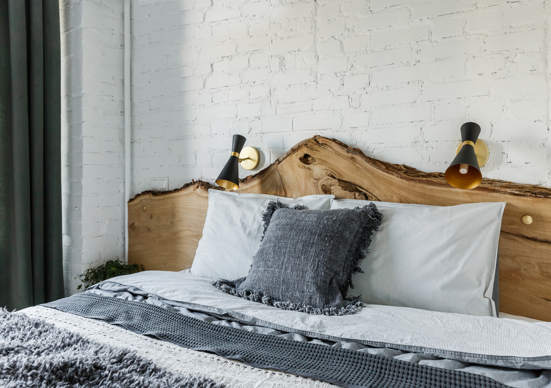 Căn phòng khiến người ta mê mẩn bởi kiểu dáng như tấm gỗ tự nhiên của thân cây đưa vào đầu giường, phía sau là tường gạch sơn trắng càng làm tôn lên vẻ đẹp của nó.