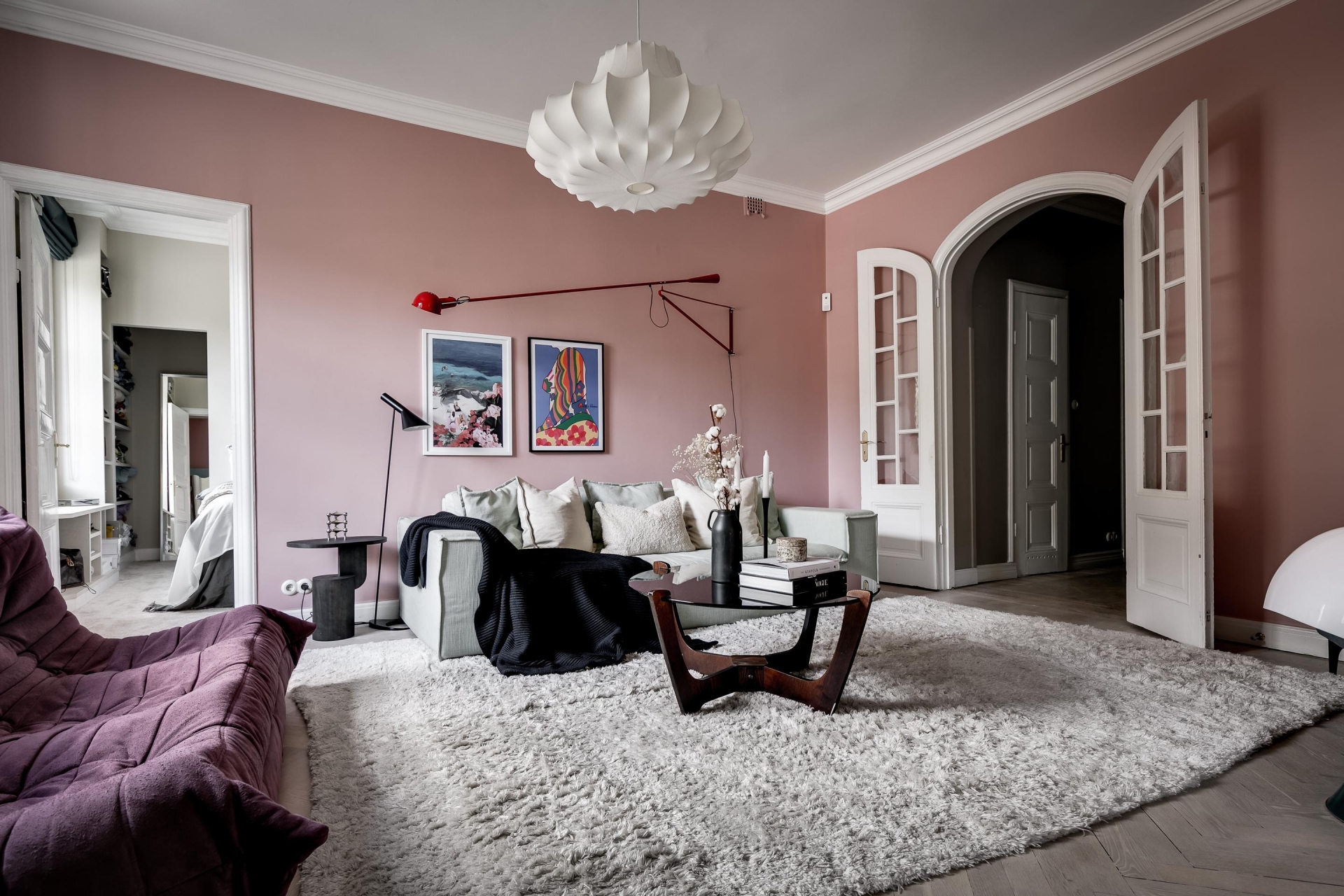 Phòng khách trong căn hộ của một nữ blogger thời trang người Thụy Điển, với phông nền tường màu hồng ngọt ngào, nội thất cầu kỳ, nhờ vậy mà tấm thảm trải sàn màu xám nhạt đã cân bằng lại cái nhìn cho không gian không bị 'rối'.