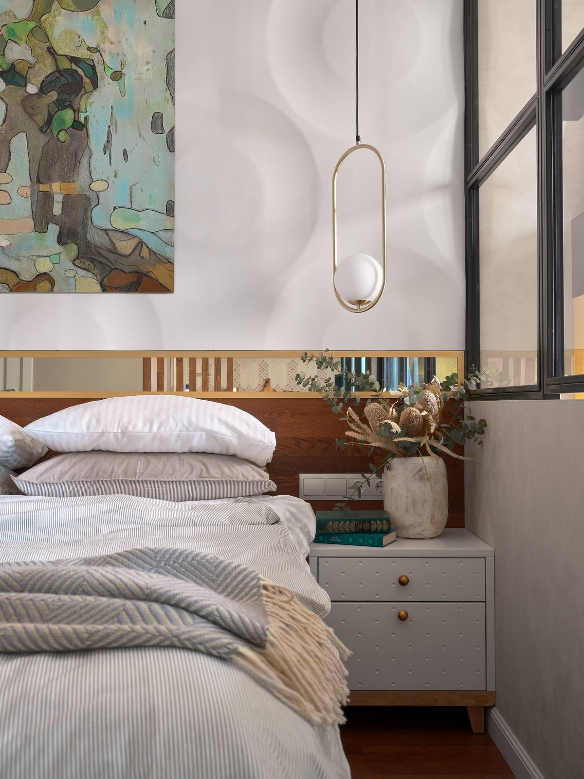 Phòng ngủ được đầu tư hệ thống đèn thả trần và táp đầu giường đối xứng với nhau tạo nên sự cân đối cho không gian. Phía trên đầu giường được ốp một tấm gương có chiều dài bằng với bề ngang độc đáo.